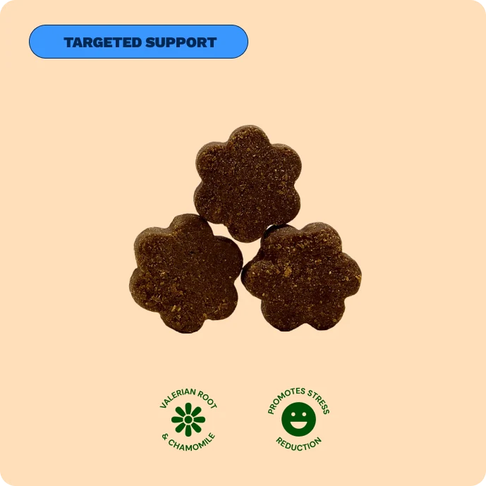 Three flower-shaped brown dog treats with icons for valerian root, chamomile, and stress reduction.