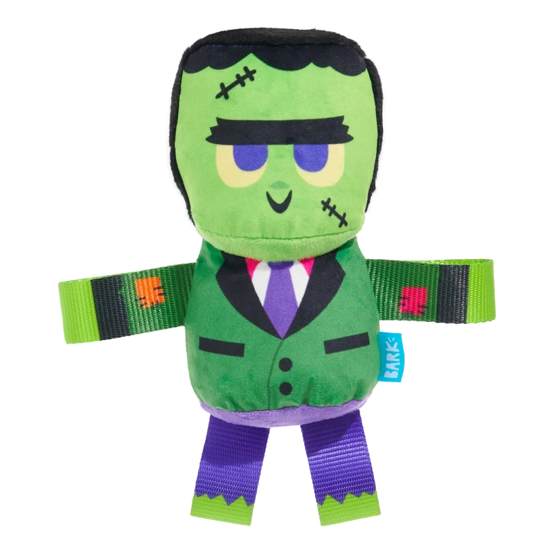 BARK Halloween Frankenstein's Party Monster plush dog toy, green with purple accents, on black background.