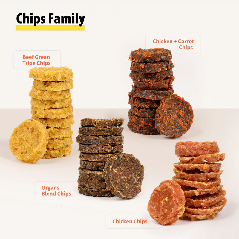 Four stacks of natural dog treat chips in beef tripe, organ blend, chicken, and chicken carrot flavors on white surface
