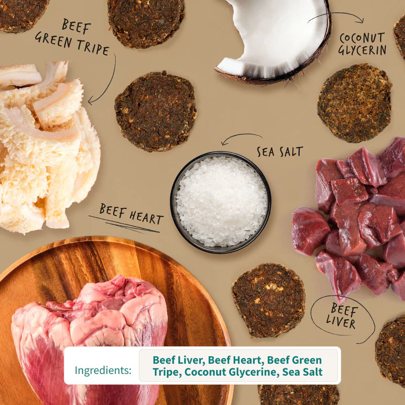 Round natural dark dog treat chips surrounded by raw beef liver, heart, green tripe, coconut pieces, and sea salt bowl