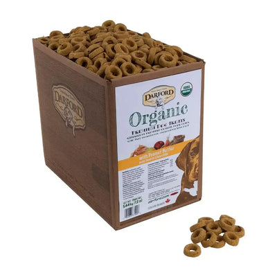 A 12-lb box of Darford® Organic Premium Peanut Butter Dog Treats by Darford, with round brown treats—some scattered outside. The label features a dog’s face and product details.