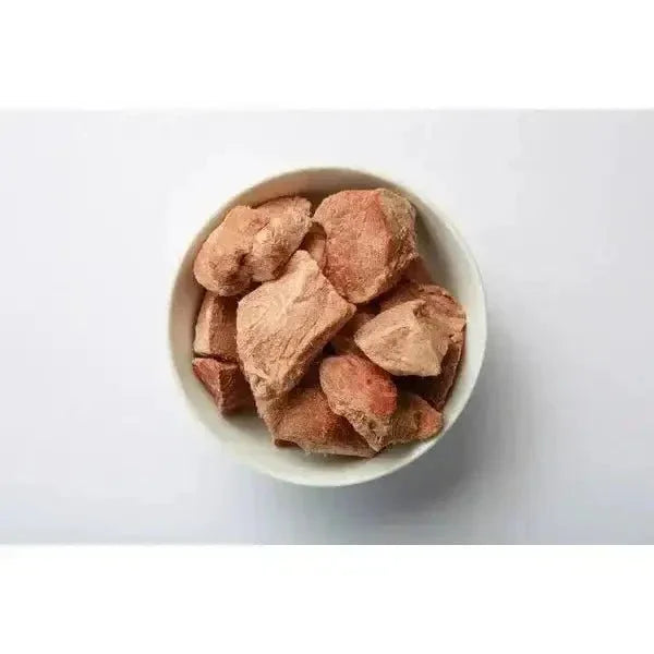 Momentum freeze-dried pork tenderloin cat treat pieces in a white bowl, showing a natural meaty texture.