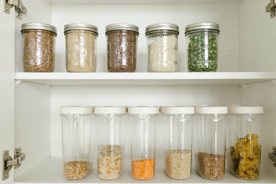 Neatly arranged pantry showcasing grains in glass jars and dry goods in plastic containers.