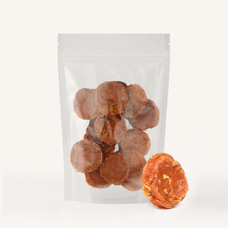 Clear resealable pouch filled with round chicken-flavored dog treat chips and one chip displayed outside