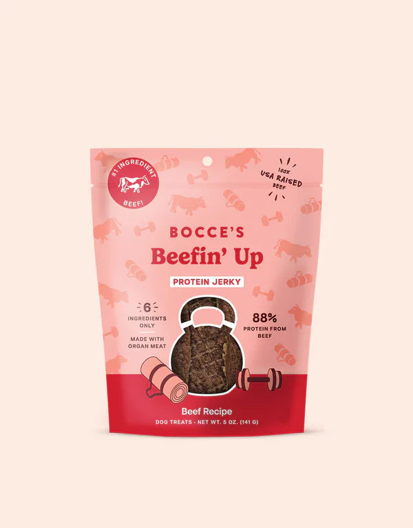 Bocce's Bakery Beefin' Up Jerky Protein Cuts 5oz, featuring a pink package with a dog treat illustration and nutritional high