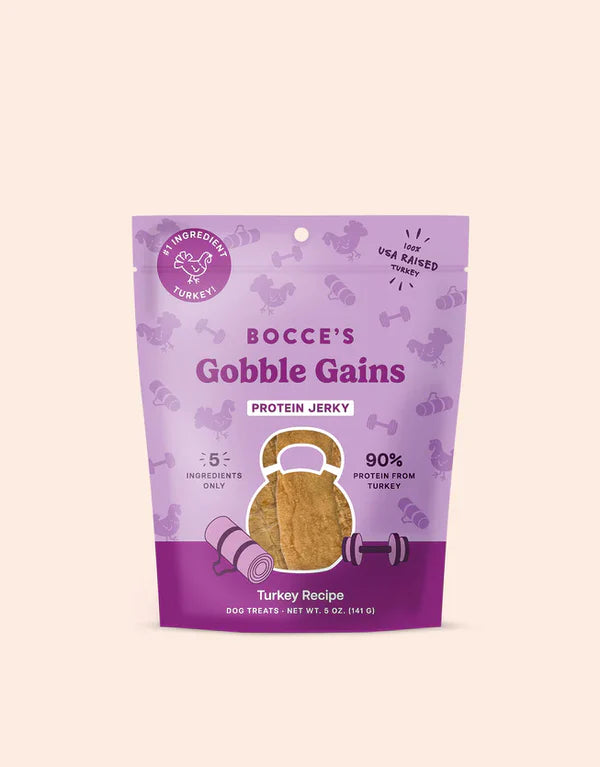 Bocce's Bakery Gobble Gains Jerky Protein Cuts 5oz, turkey recipe dog treats in a purple bag with a clear window.