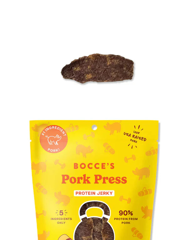 Bocce's Bakery Pork Jerky Dog Treats 5oz package with a piece of jerky above, featuring a bright yellow design and pork graph