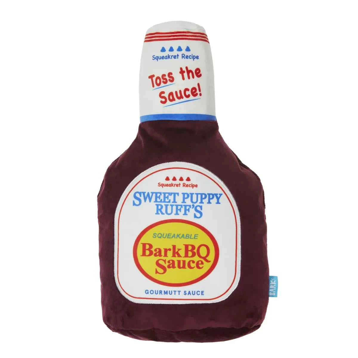 BARK Big Dog BarkBQ Sauce plush dog toy shaped like a barbecue sauce bottle with pun-filled labels.