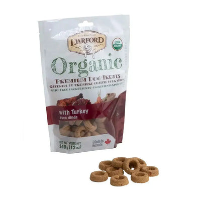 A bag of Darford® Organic Premium Turkey Dog Treats (340g/12oz) stands upright, with several round, brown treats in front. The white package with green and red accents highlights these healthy USDA organic treats from Darford.