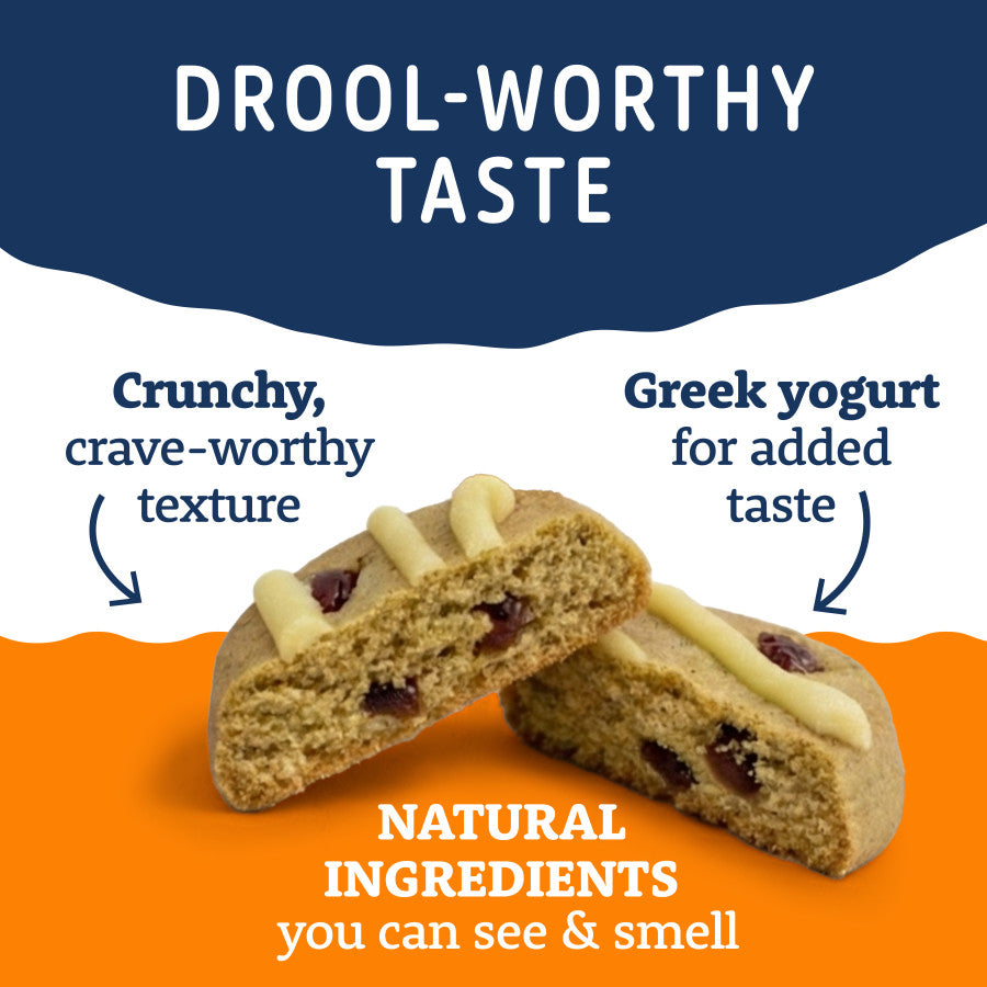 Two halves of a crunchy dog treat with visible cranberries and a Greek yogurt drizzle.