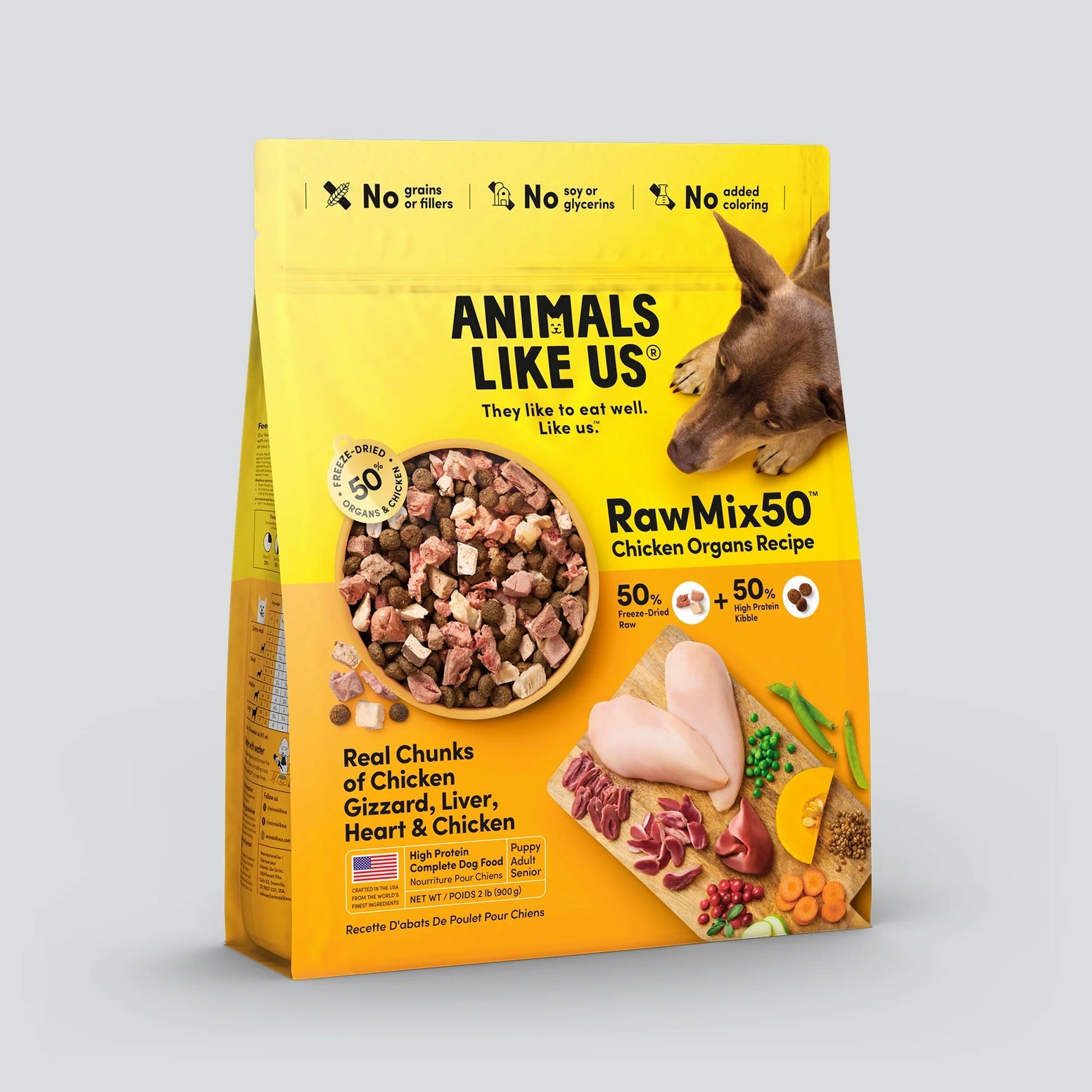 Yellow bag of freeze-dried chicken organ chunks with natural ingredients and a dog sniffing nearby on a gray background
