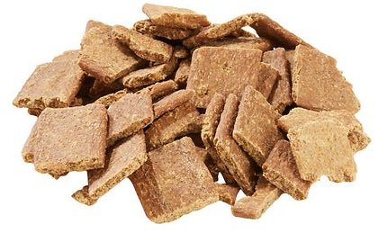 A pile of square-shaped, brown rabbit jerky dog treats with a textured surface.